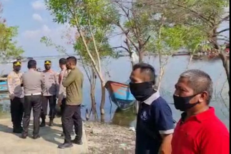 Central Java Regional Police head Inspector General Ahmad Luthfi and his officers confer on the shores of the Kedung Ombo Reservoir after a tourist boat capsized in the waterway on Saturday, (15/5/2021)
