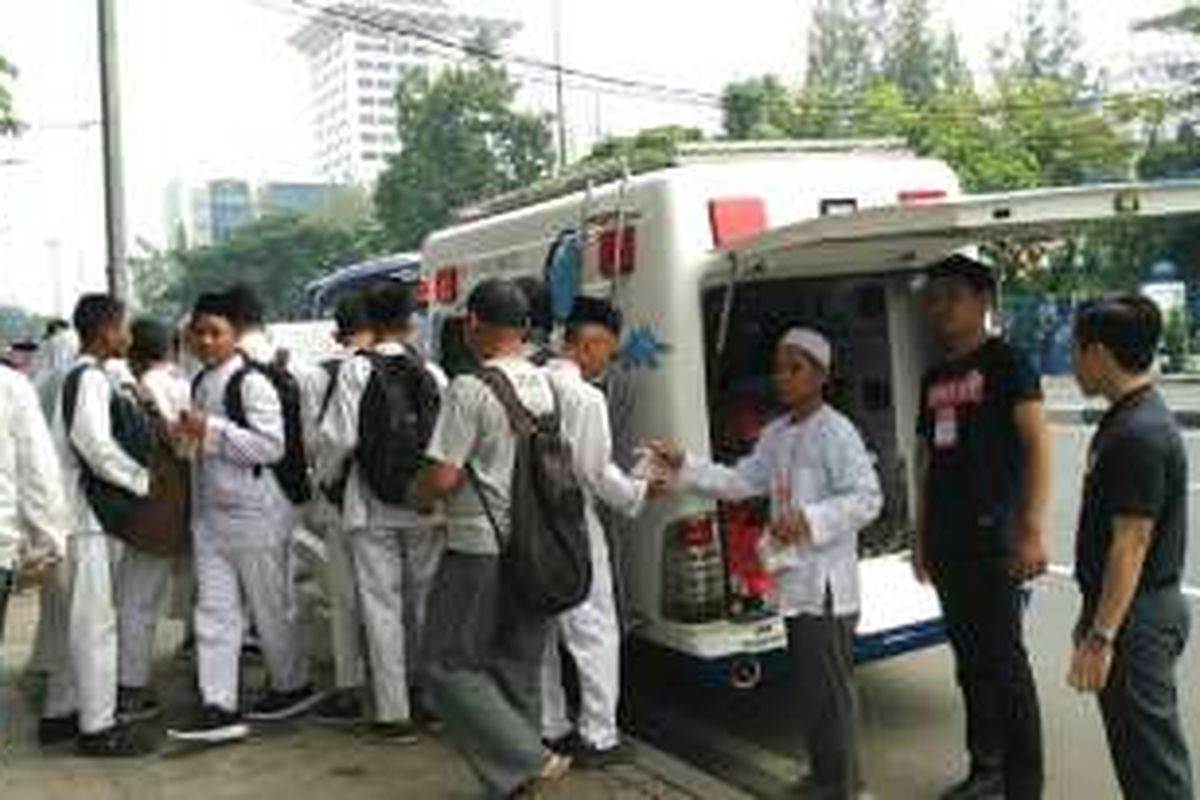 Petugas Rumah Sakit Ibu dan Anak (RSIA) Ummi Bogor, Jawa Barat, membagikan makanan kepada demonstran di Jalan Medan Merdeka Timur, Jakarta Pusat, Jumat (4/11/2016).