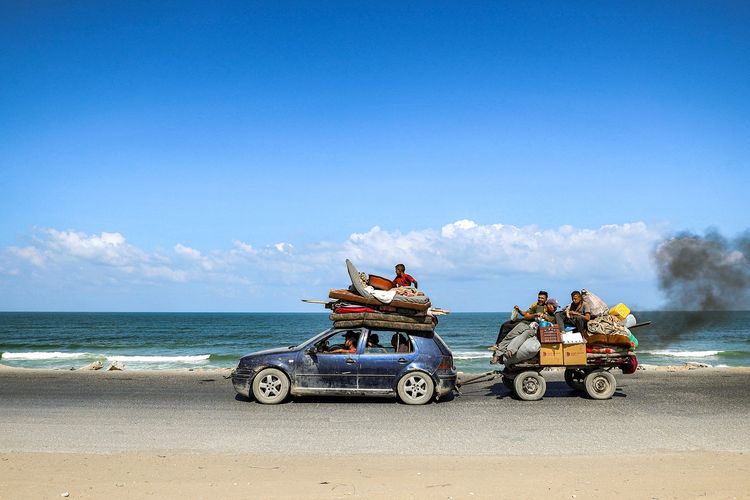 Sebuah mobil menderek kendaraan di belakangnya saat warga Palestina kembali mengungsi dari kamp pengungsian Nuseirat di Gaza Tengah, 9 September 2025, setelah Israel memerintahkan evakuasi sebelum melancarkan serangan lagi.