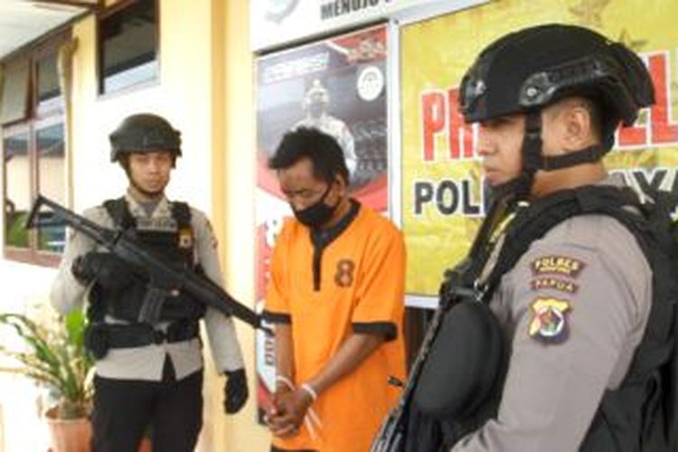 Pelaku penikaman mantan istri hingga tewas berinisial N(38) menggunakan baju orange dengan masker hitam, saat diamankan di Mapolres Jayapura, Selasa (23/05/2022).