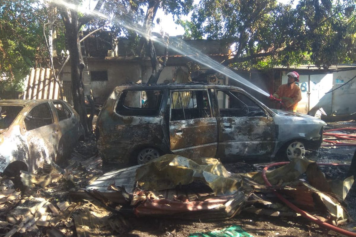 Petugas saat memadamkan api yang membakar garasi di Jalan Usman Sadar nomor 67, Kelurahan Karangturi, Kecamatan/Kabupaten Gresik, Jawa Timur, Selasa (18/6/2024).