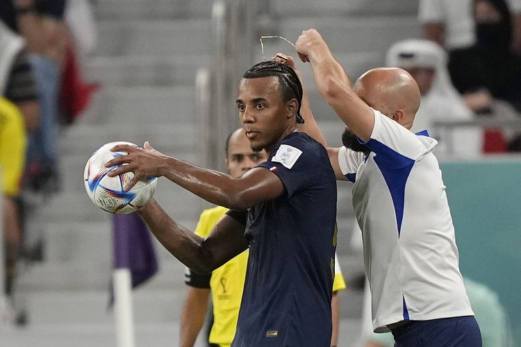 Asisten pelatih melepas kalung yang dipakai bek Perancis Jules Kounde dalam pertandingan babak 16 besar Piala Dunia 2022 antara Perancis vs Polandia di Stadion Al Thumama, Qatar, Minggu (4/12/2022).