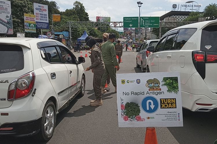 Sejumlah kendaraan terlihat diberhentikan saat hendak menuju kawasan Puncak Bogor di sekitar Simpang Gadog, Kecamatan Ciawi, Kabupaten Bogor, Jawa Barat, Jumat (12/2/2021).
