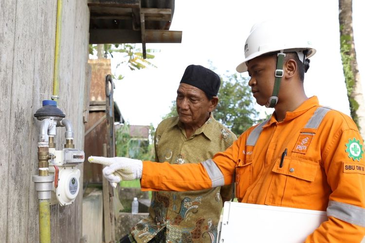 Petugas PT Perusahaan Gas Negara Tbk (PGN) sedang mengecek gas meter pelanggan jaringan gas rumah tangga.