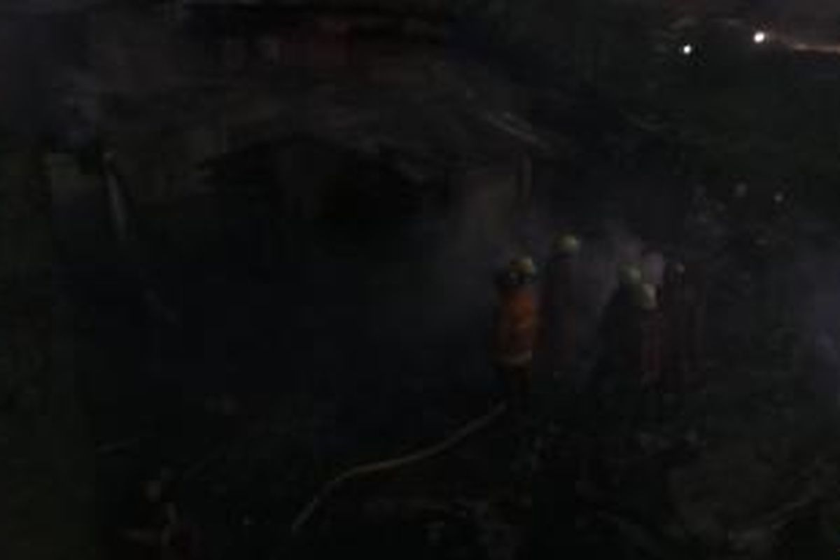 Nampak dari atas jembatan di Jalan Basuki Rahmat depan Pasar Gembrong, Jatinegara, Jakarta Timur, puluhan petugas pemadam sedang memadamkan api yang melahap pemukiman semi permanen di pinggiran Kali Cipinang belakang Pasar Gembrong. Selasa (4/8/2015).