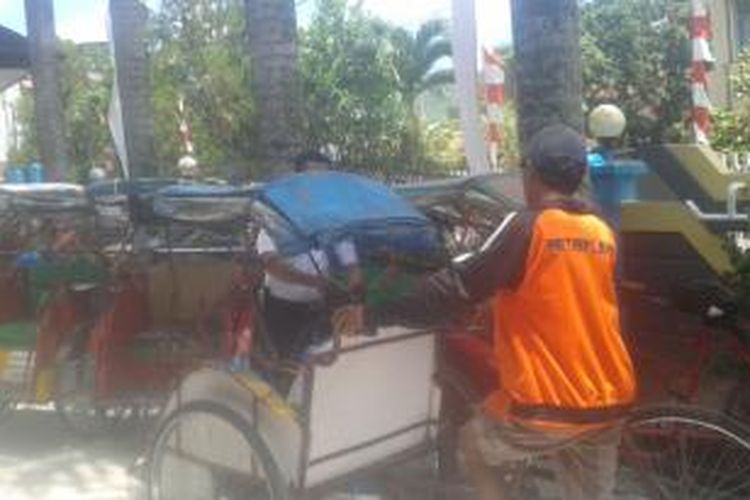 Petugas Dishub Kota Ambon menggembok sebuah becak di belakang Kantor Wali KOta Ambon, Selasa (15/9/2015). becak itu digembok karena melintas di jalan yang dilarang oleh pemerintah Kota Ambon 