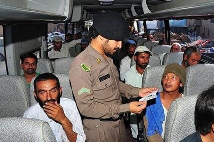 Petugas keamanan publik memeriksa dokumen ekspatriat di dalam sebuah bus di Riyadh.