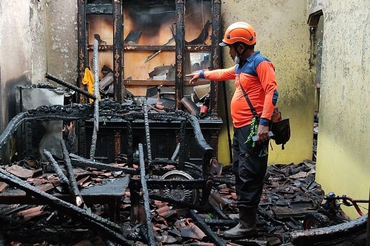 Petugas BPBD Kabupaten Cirebon menunjukan bagian ruang tamu rumah Didi warga desa Dukupuntang Kecamatan Dukupuntang Kabupaten Cirebon, yang terbakar pada Rabu (24/4/2024) petang.