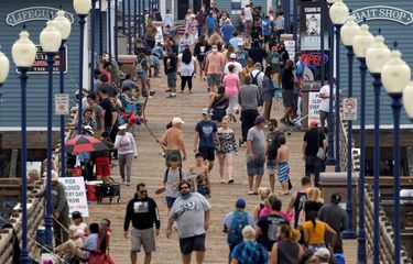 Beberapa orang memakai masker saat berjalan di dermaga, ditengah pandemi virus corona (COVID-19) di Oceanside, California, Amerika Serikat, Senin (22/6/2020). 