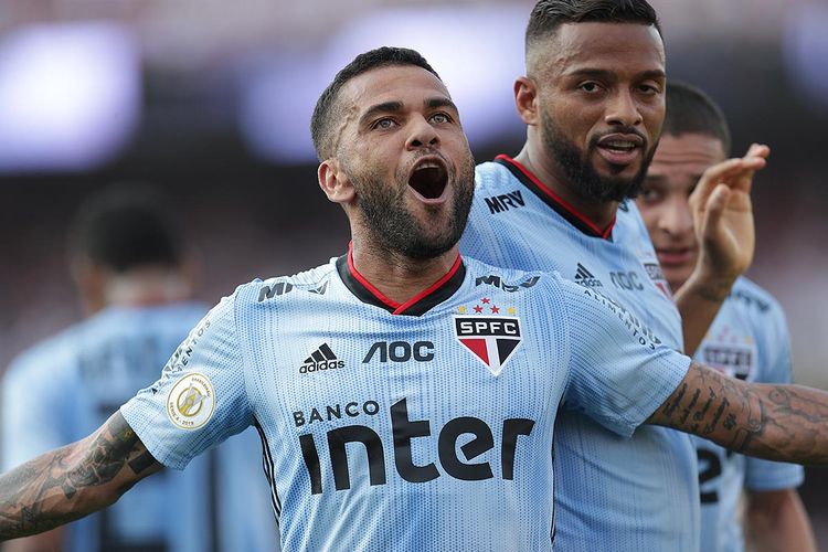 Pemain Sao Paulo, Dani Alves, merayakan gol yang ia cetak ke gawang Ceara pada ajang Liga Brasil, Minggu (18/8/2019).