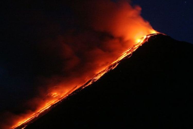 Lava pijar meluncur dari kawah Gunung Api Karangetang saat erupsi.