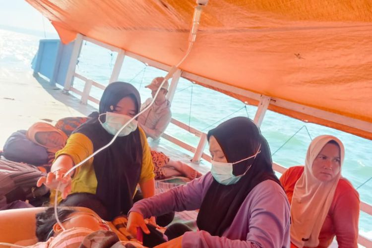 Bidan Sri Wahyuni dan Rinawati yang berusaha tetap siaga di atas perahu raksi saat merujuk Masrifatul Firdaus, seorang ibu yang sedang hamil 7 bulan dari Pulau Sepudi menuju rumah sakit daratan Sumenep, Jawa Timur. 