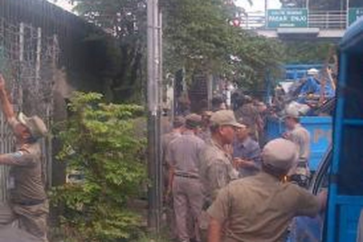 Puluhan petugas satuan polisi pamong praja membongkar lapak-lapak pedagang kaki lima di sepanjang Jalan Raya Bekasi Timur, Kelurahan Cipinang Besar Utara, Jatinegara, Jakarta Timur, Selasa (23/7/2013).