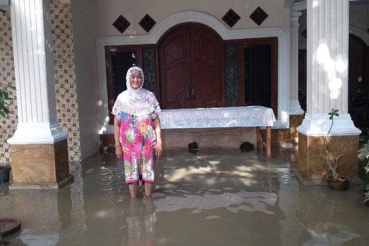 Hj Komariyah ibunda Iis Dahlia saat di depan rumahnya tergenang banjir di Indramayu, Jabar. 