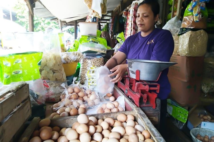 Laily, pelayan toko klontong milik Bu Abbas di Pasar Legi Jombang Jawa Timur, saat melayani pembeli telur di lapak tempatnya bekerja, Jumat (20/12/2019).