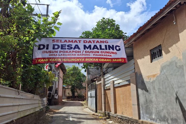 Baliho bertuliskan selamat datang di desa maling dipasang oleh warga Desa Larangan Badung, Pamekasan, Rabu (20/8/2025)