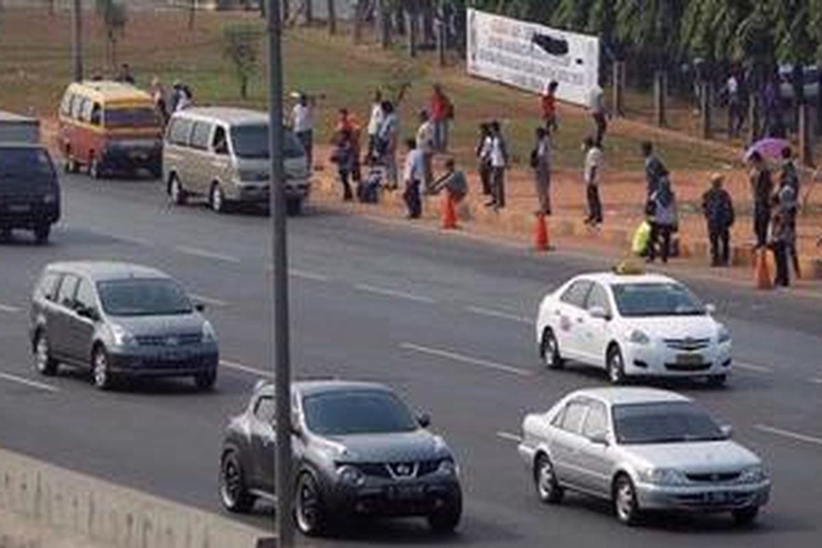 Penumpang turun dan menunggu bus di terminal bayangan (ilegal) di ruas Tol Jatibening Kilometer 8, Pondok Gede, Kota Bekasi, Senin (9/7/2012). Meski sudah ada penertiban dan larangan menaikturunkan penumpang oleh PT Jasa Marga (Persero), pengelola jalan Tol Jakarta-Cikampek namun tiap hari kejadian berulang. Penghitungan Jasa Marga mulai pukul 06.00 hingga 14.00 sebanyak 936 kendaraan menaikturunkan penumpang di lokasi tersebut. 