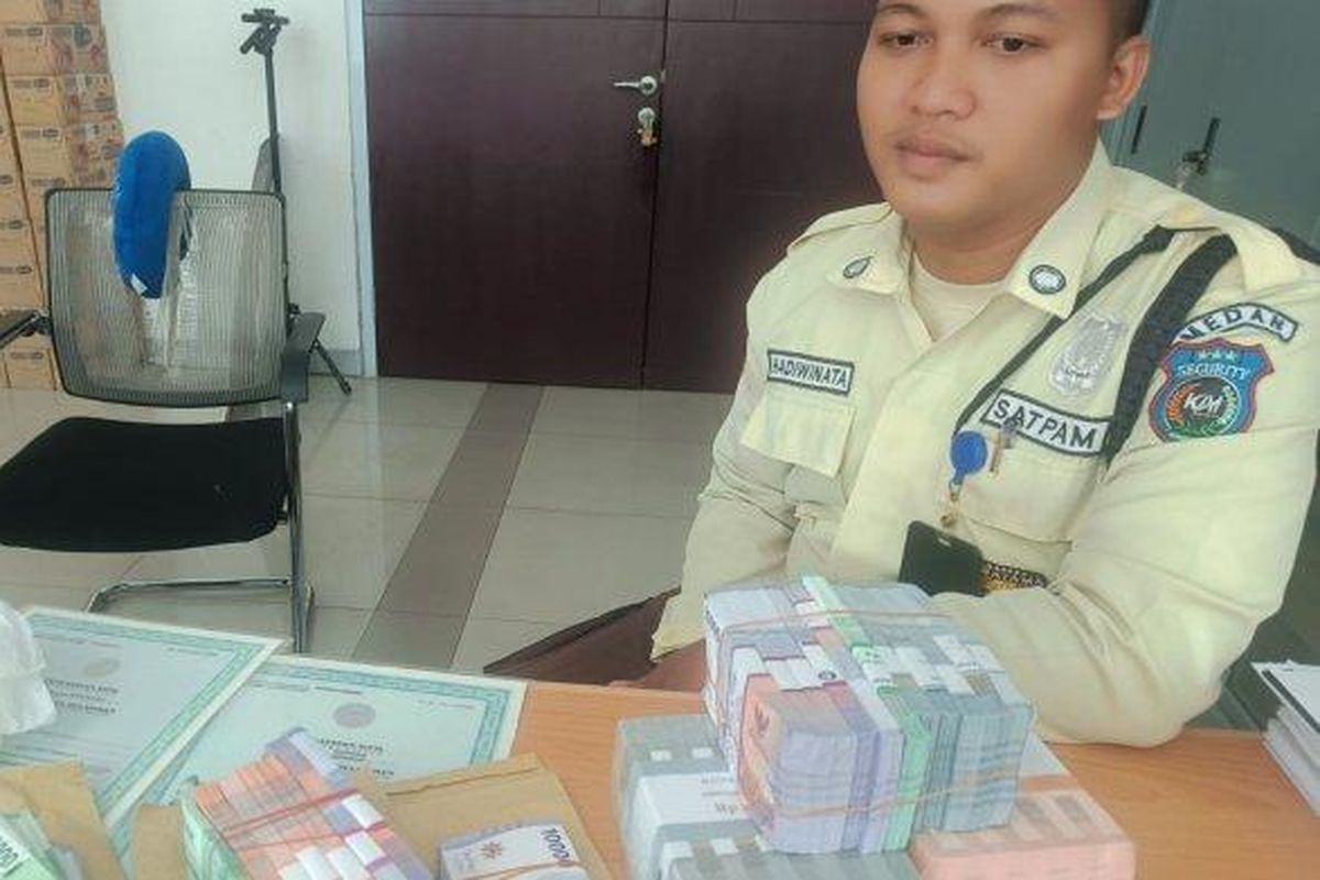 Sekuriti Kereta Api Bandara Medan menunjukkan uang milik penumpang yang ditemukan di Stasiun Kereta Api Bandara Medan di Jalan Jawa, Kota Medan, Senin (22/4/2024).

