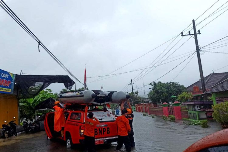 Petugas dan relawan BPBD Kabupaten Blitar melakukan evakuasi terhadap warga yang terjebak di rumahnya akibat banjir, Senin (17/10/2022)