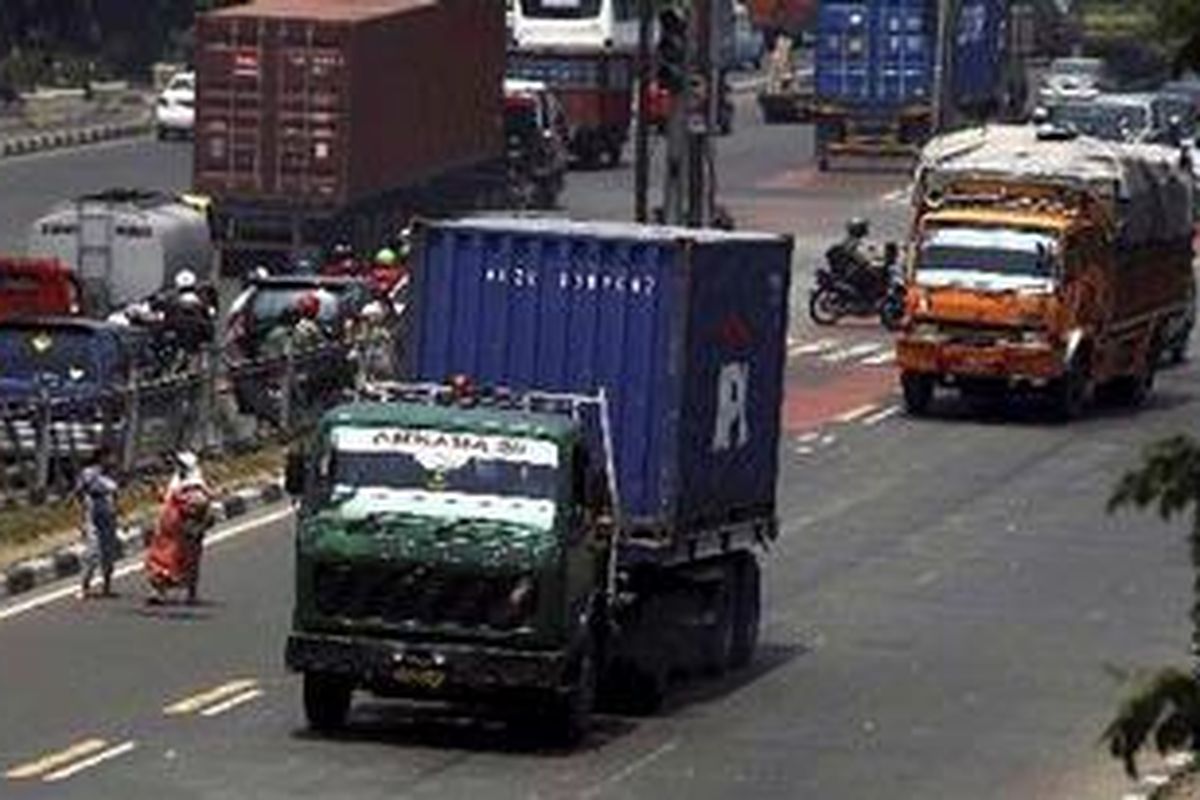 Sejumlah truk peti kemas melewati Jalan Yos Sudarso menuju pelabuhan Tanjung Priok, Jakarta Utara, Rabu (13/4/2011). PT Pelabuhan Indonesia II menolak pembatasan waktu operasional angkutan berat atau truk di dalam kota karena 2,3 juta peti kemas barang di Pelabuhan Tanjung Priok merupakan angkutan langsung dan didominasi logistik makanan yang harus langsung diangkut ke daerah tujuan. Menurut Direktorat Lalu Lintas Polda Metro Jaya, pembatasan truk sangat penting untuk mengatasi kemacetan. Jika pembatasan ini diberlakukan, setidaknya 30 persen kemacetan di Jakarta bisa diurai.