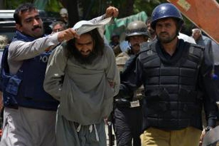 Seorang pengikut ulama Tahir-ul-Qadri ditahan polisi Pakistan usai bentrokan yang terjadi pada Selasa (17/6/2014), di kota Lahore, Pakistan.