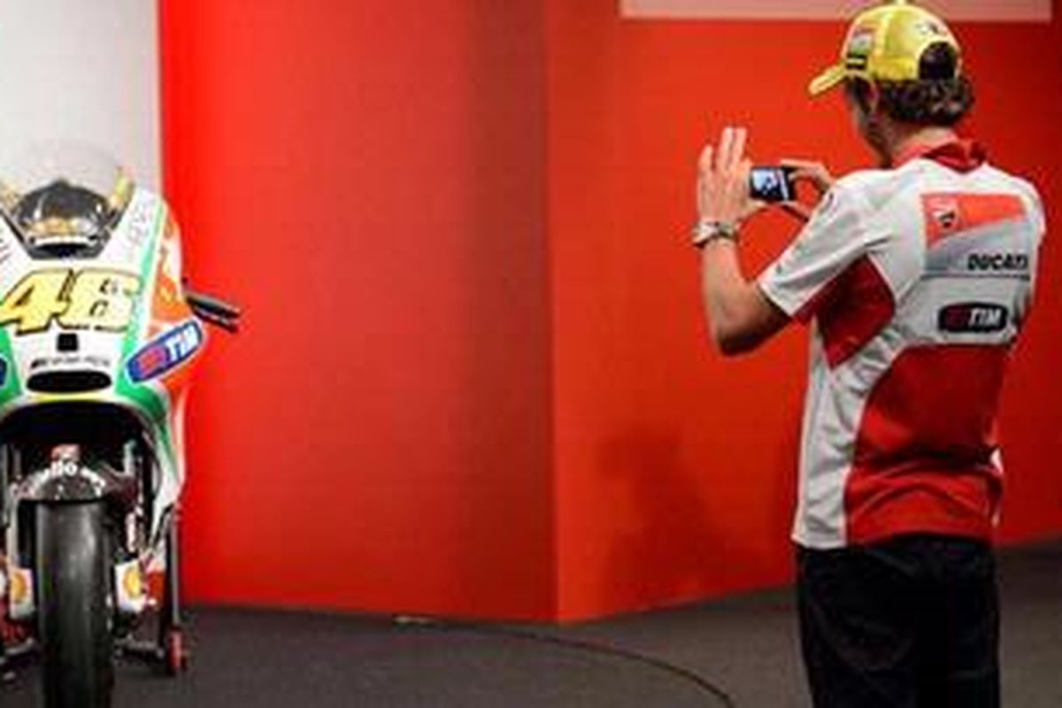 Pebalap Ducati, Valentino Rossi, memotret Desmosedici GP12 yang baru diluncurkan pada Senin (19/3/12), untuk memperlihatkan desain warna baru.