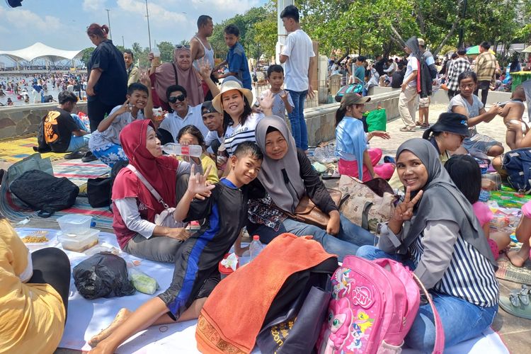 Purnawati (38) (kanan) warga Bogor yang berpiknik dengan keluarga di Pantai Ancol