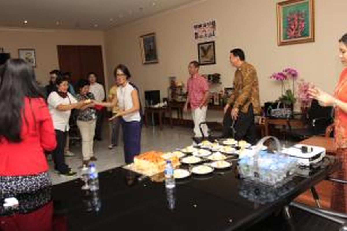 Nina Tamam tengah memberikan potongan kue untuk salah satu wartawan yang hadir di ruang kerja Wakil Gubernur DKI Jakarta, Basuki Tjahaja Purnama, Jumat (29/8/2014). Basuki memberikan kejutan berupa kue tart untuk merayakan ulang tahun ke-12 pernikahan penyanyi Nina Tamam dengan Erikar Lebang.