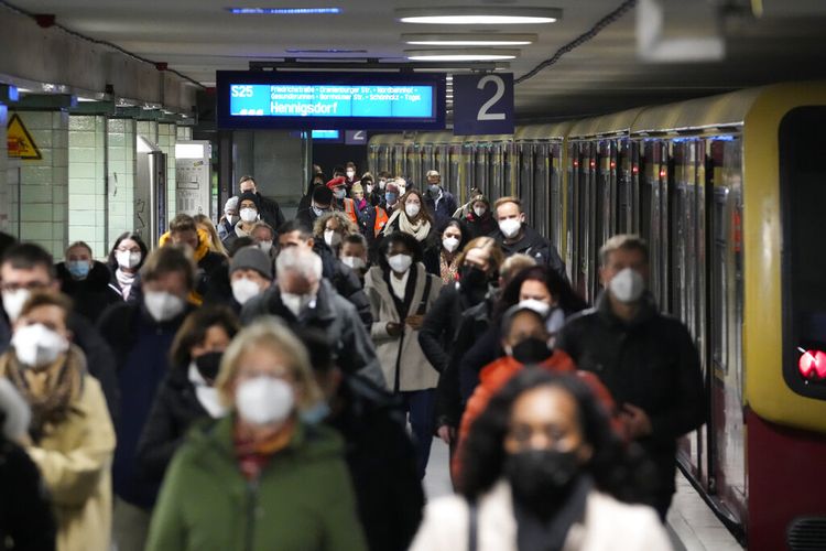 Para pengguna komuter mengenakan masker wajah melindungi diri dari virus corona saat mereka tiba di stasiun transportasi umum Brandenburger Tor di Berlin, Jerman, Jumat (12/11/2021). Jerman memerangi gelombang keempat virus corona dengan jumlah infeksi yang tinggi dalam beberapa hari terakhir .