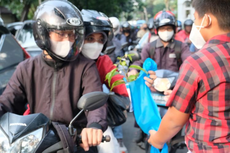 Siswa Sekolah Tarakanita 3 bagikan tanaman untuk pengendara yang melintasi jalan dalam rangka Hari Ozon Internasional, Jumat (16/9/2022).