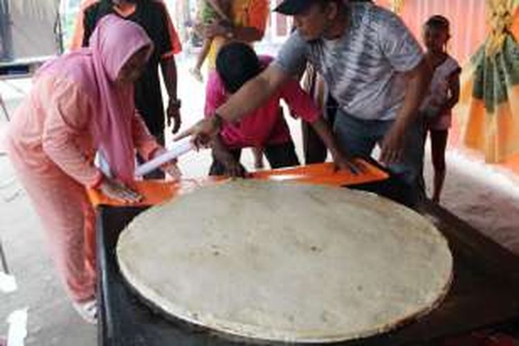 Warga desa Dembe 1 Kota Gorontalo menyiapkan kue apangi (apem) yang baru dimasak dalam sebuah tempat. Kue ini akan disantap beramai-ramai untuk memperingayi Hari Asyura 10 Muharram