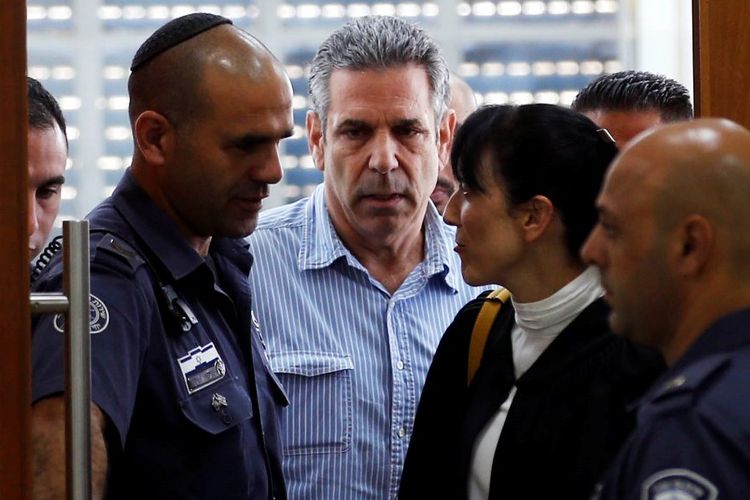 Gonen Segev (tengah), mantan menteri energi dan infrastruktur Israel, saat memasuki ruang persidangan di Yerusalem, pada 5 Juli 2018.