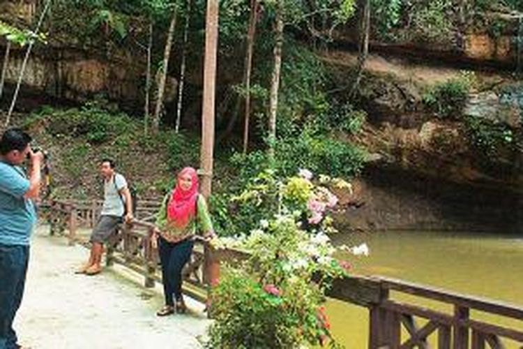 Pengunjung mengabadikan diri dengan kamera di tempat wisata Air Terjun Batu Mahasur, Kuala Kurun, Kabupaten Gunung Mas. Tempat wisata itu berada di kawasan lindung seluas 100 hektar yang dikelola dinas kehutanan.