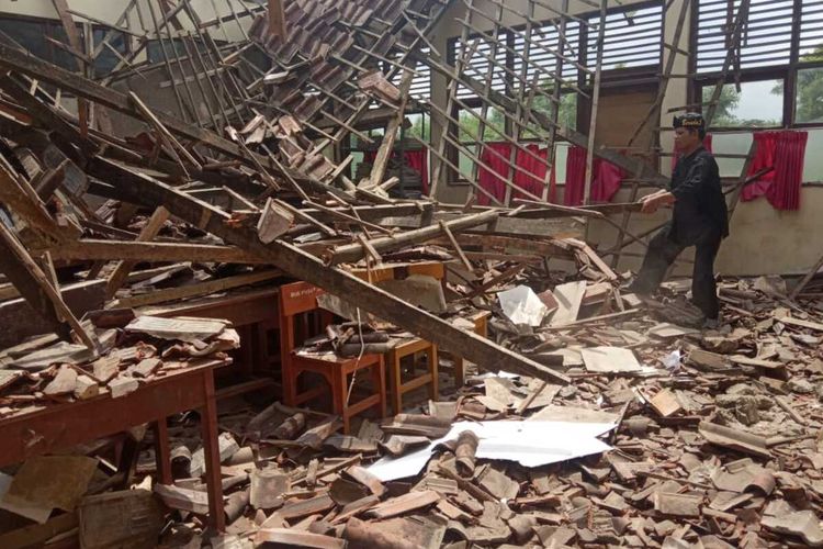 Andi Setyowijaya, seorang pengajar, meninjau ruang kelas SDN Karawang Kulon III yang atapnya ambruk, Minggu (9/2/2020).