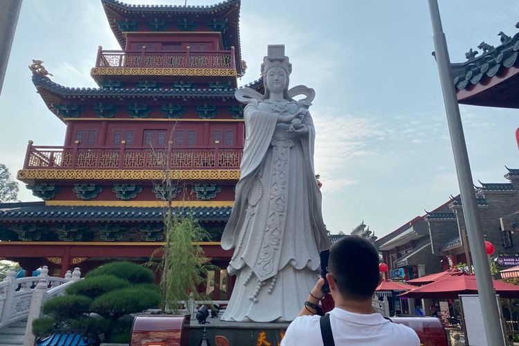 Salah satu pengunjung yang mengambil gambar patung Dewi Mazu serta pagoda di Old Shanghai, menggunakan kamera ponsel, Selasa (13/9/2022). 