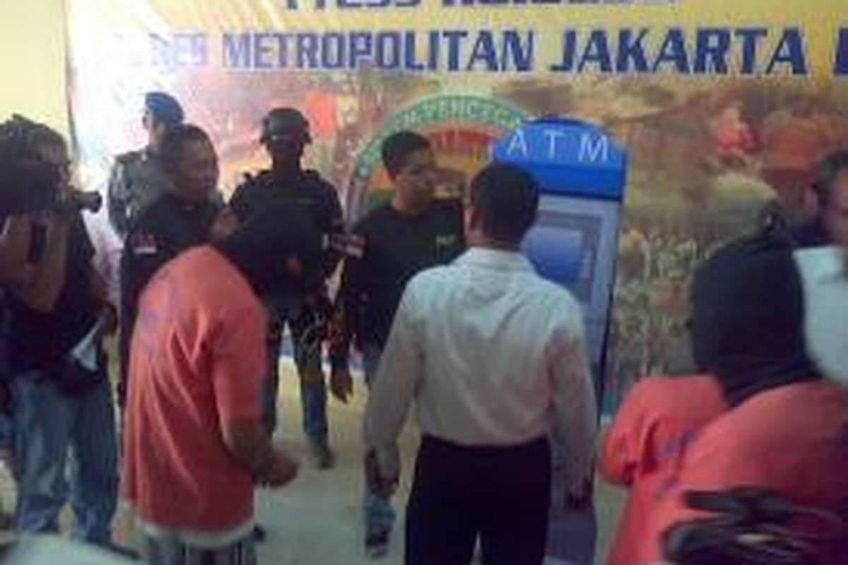 Pelaku meragakan ulang aksi kejahatannya. Pelaku berperan sebagai pengguna ATM yang sedang mangantri, Selasa (17/3/2015)