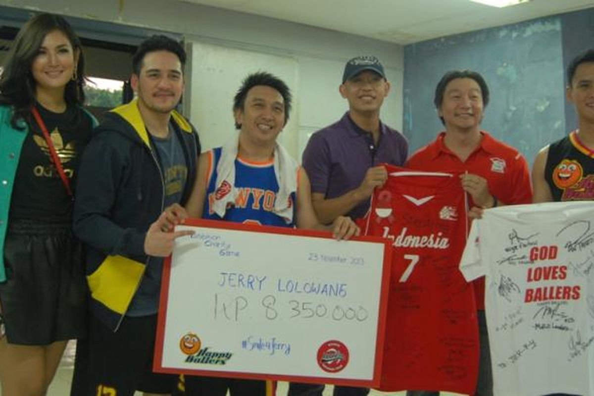 mantan pebasket Satya Wacana LBC Angsapura Salatiga (sekarang Satya Wacana Metro LBC Bandung), Jerry Lolowang (tengah, kemeja ungu) menerima jersey serta sejumlah uang hasil pertandingan eksibisi antara timnas basket putri melawan Happy Ballers yang digagas oleh Augie Fantinus (ketiga dari kiri), di Hall Basket Senayan, Jakarta, Rabu (27/11/2013). 