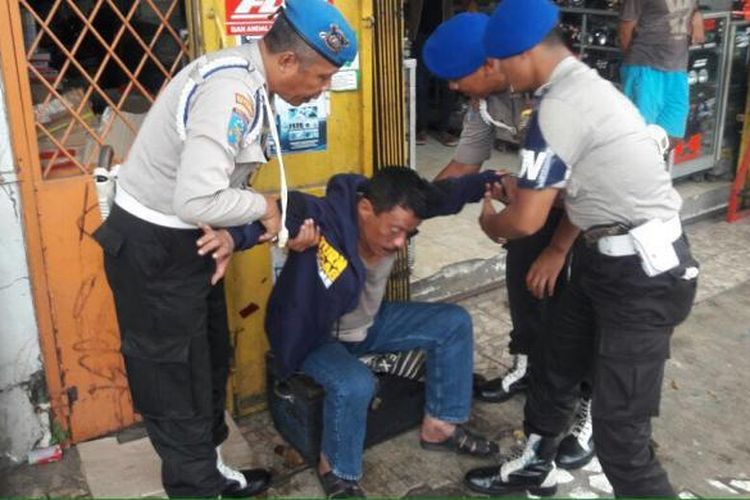 Wakapolsek Kemayoran AKP Jamal Alkatiri saat diamankan Paminal Polres Jakarta Timur seusai mengacungkan senjata ke arah warga di Jalan Otista, Jakarta Timur pada Senin (8/8/2016).
