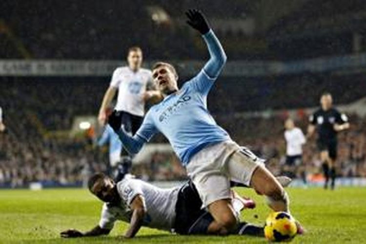Bek Tottenham Hotspur, Danny Rose, melanggar penyerang Manchester City, Edin Dzeko, saat kedua tim bertemu dalam lanjutan Premier League, Rabu (29/1/2014). 