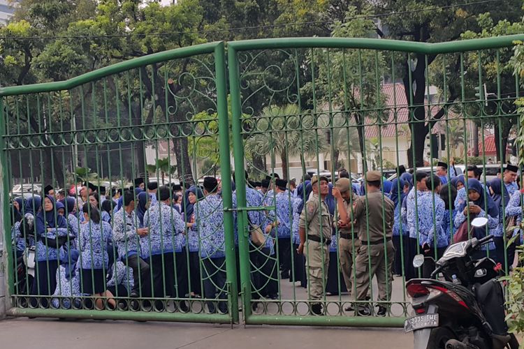 Ratusan pegawai negeri sipil (PNS) DKI Jakarta yang terlambat mengikuti upacara peringatan hari rapat raksasa IKADA ke-72 berkumpul di trotoar dekat Lapangan IRTI, Monas, Jakarta Pusat, Selasa (19/9/2017) pagi.