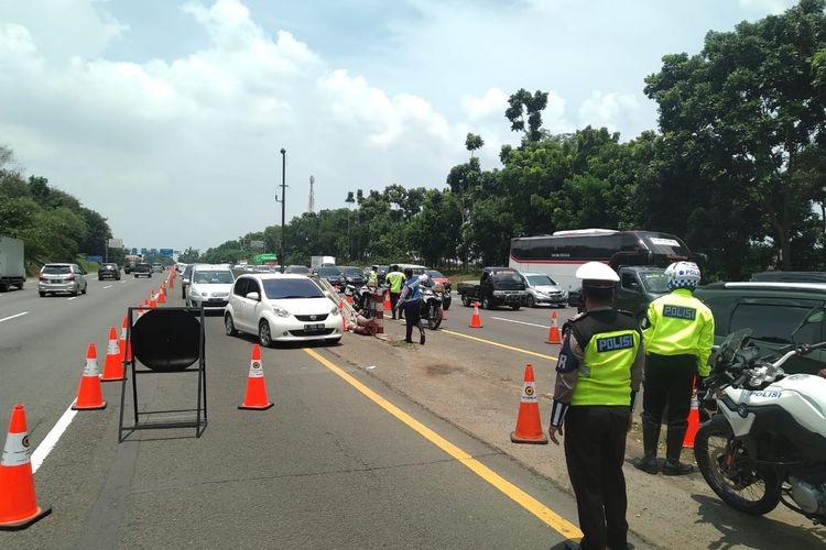 Petugas mengatur arus lalu lintas di lokasi penerapan contraflow Tol Jakarta-Cikampek arah Cikampek, Kamis (29/10/2020)