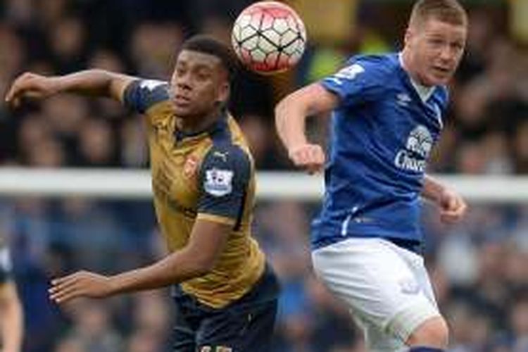 Winger Arsenal, Alex Iwobi (kiri), berduel dengan pemain Everton, James McCarthy, pada lanjutan Premier League di Stadion Goodison Park, 19 Maret 2016.