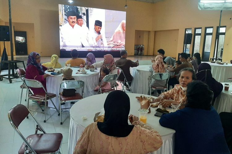 Suasana warga saat menonton melalui layar lebar di gedung serbaguna. warga menyaksikan acara di kediaman Erina Gunodo sembari menikmati kuliner gratis UMKM.