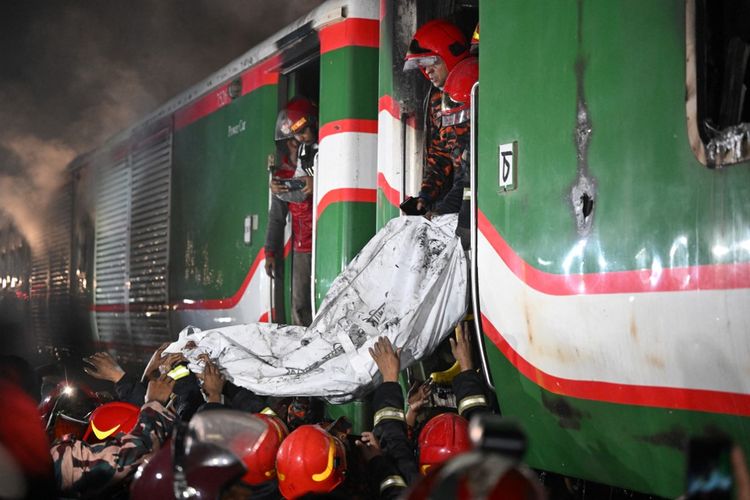 Petugas penyelamat memindahkan jenazah dari gerbong kereta Benapole Express yang terbakar di Dhaka pada 5 Januari 2024. 