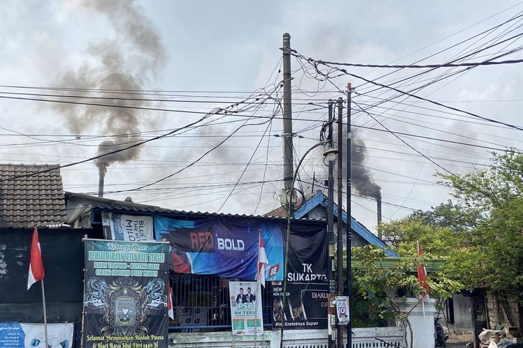 Asap hitam yang muncul dari cerobong pabrik tahu di Tropodo, Krian, Jumat (22/8/2025)