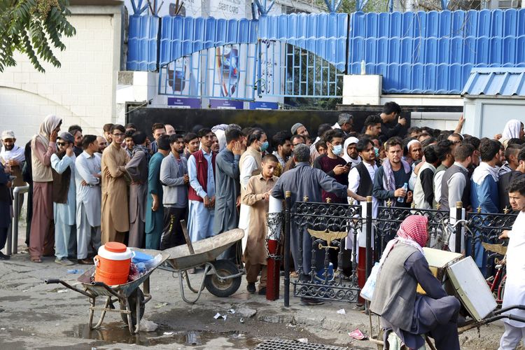 Warga Afghanistan menunggu dalam antrean panjang selama berjam-jam untuk mencoba menarik uang, di depan sebuah bank di Kabul, Afghanistan, Senin, 30 Agustus 2021.