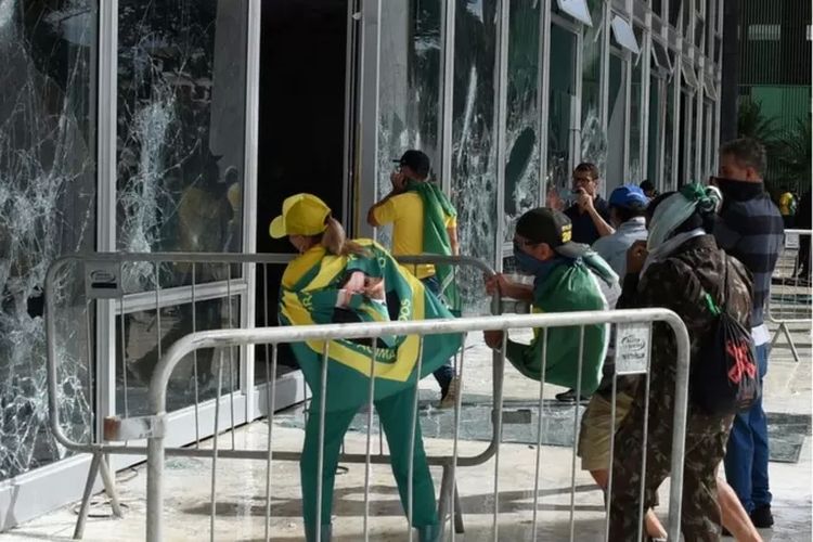 Sejumlah demonstran pendukung mantan Presiden Jair Bolsonaro memecahkan kaca Mahkamah Agung dalam serbuan di ibu kota Brasilia, 8 Januari 2023.