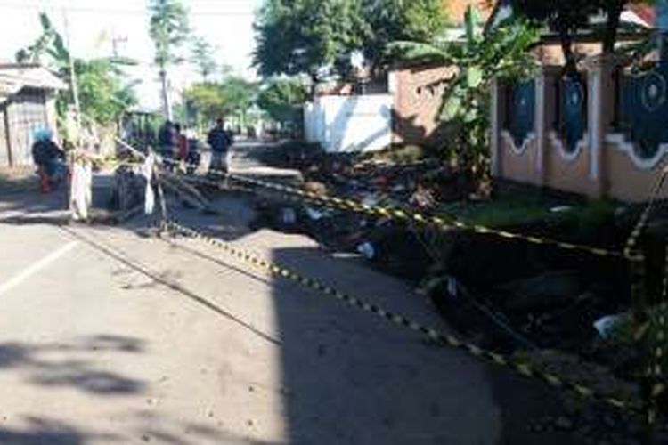 Suasana jalan raya di Desa Plinggisan, Kecamatan Kraton, Kabupaten Pasuruan, Jawa Timur yang ambles karena banjir, Jumat (1/7/2016)