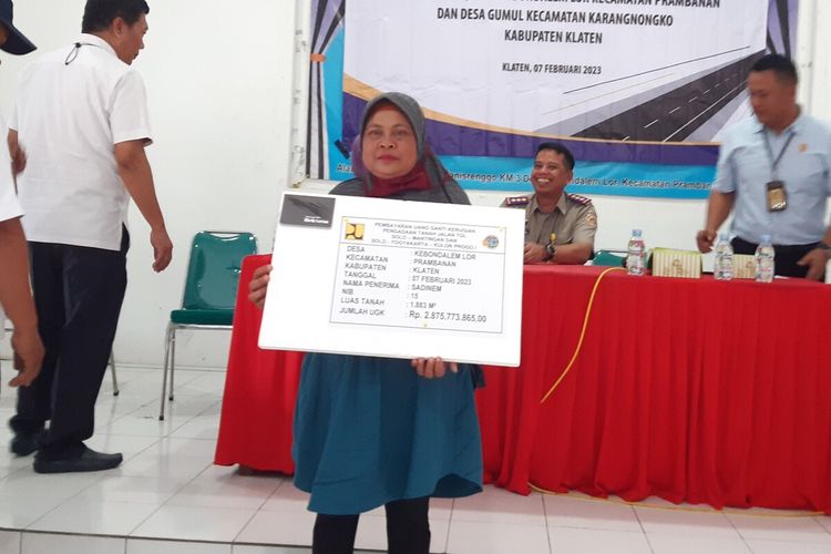 Sadinem (53), warga Kebondalem Lor, Kecamatan Prambanan, Klaten, Jawa Tengah, menerima uang pembayaran ganti kerugian pembangunan jalan tol Solo-Yogyakarta senilai Rp 2,8 miliar di Kantor Desa Kebondalem Lor, Kecamatan Prambanan, Klaten, Jawa Tengah, Selasa (7/2/2023).