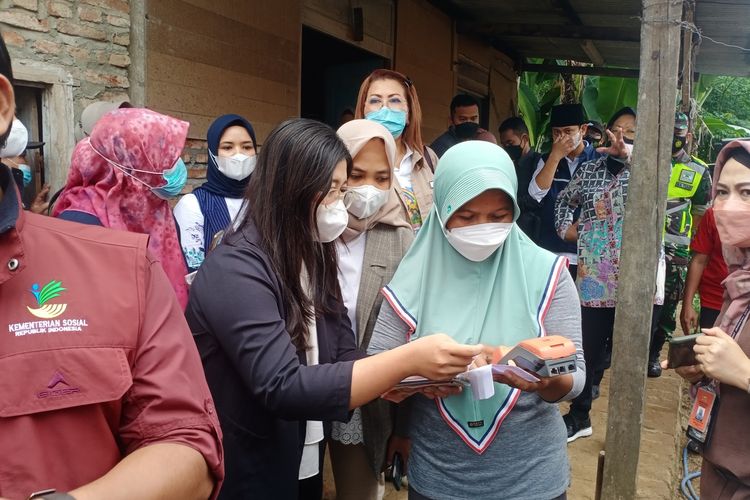 Menteri Sosial Tri Rismaharini bersama Bupati Trenggalek Mochamad Nur Arifin menyaksikan pencarian bansos milik salah satu warga KPM di Desa Melis, Kecamatan Gandusari, Kabupaten Trenggalek, Jawa Timur, Sabtu (25/12/2021).